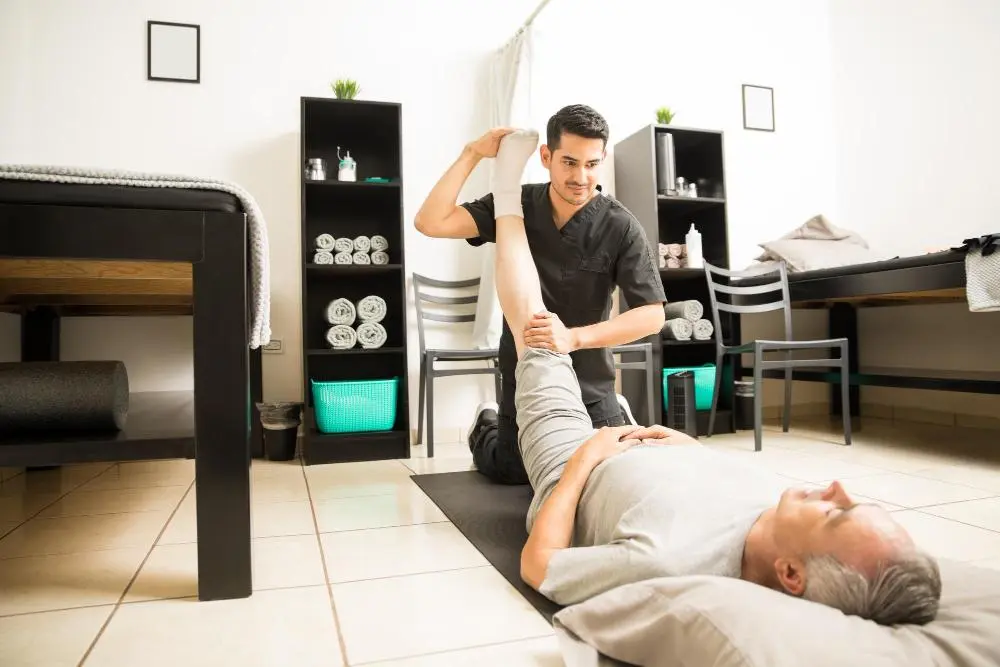 physio helping patient leg stretching